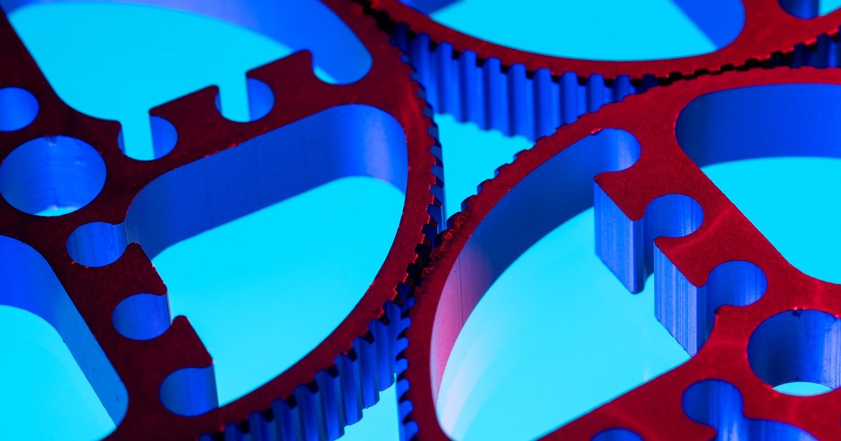 Two interlocking gears of different sizes meshing together on a plain background